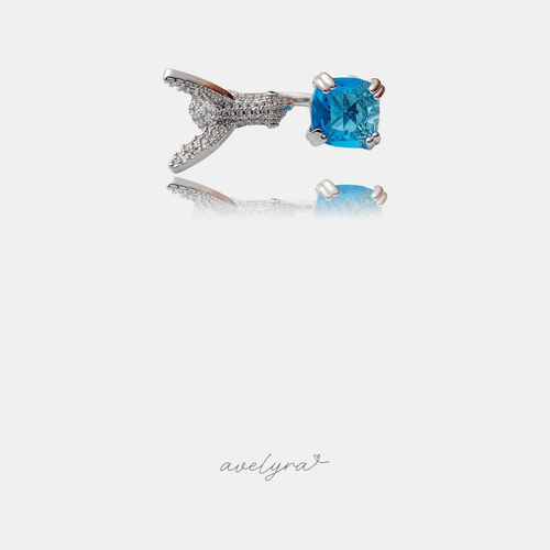 Silver-tone open ring with a pave-set wing shape and a blue cushion-cut crystal