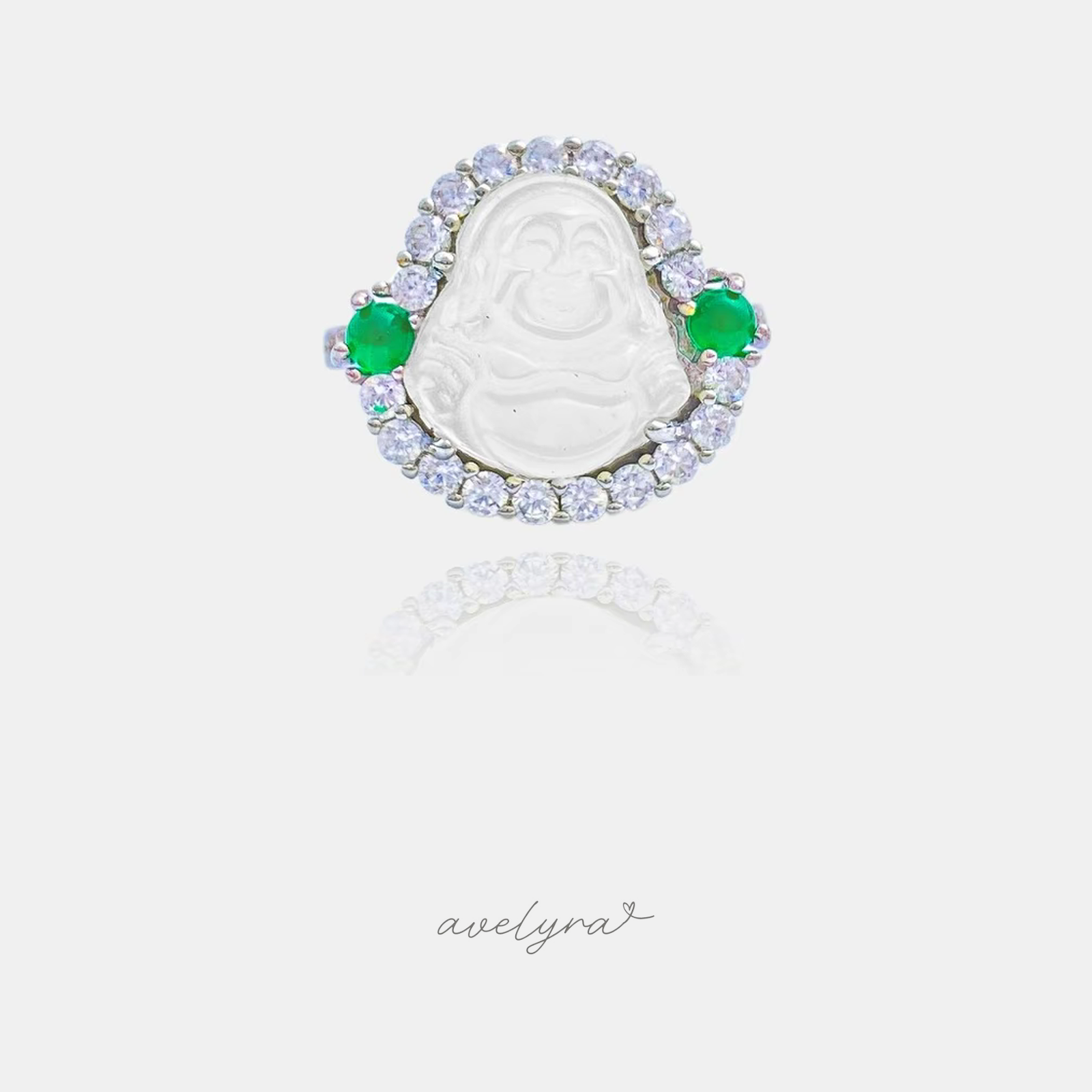 Silver-tone ring with a frosted white Buddha figure framed by a crystal halo and two green round stones