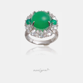 Silver-tone cocktail ring with a large round green cabochon centre framed by clear pear and round stones