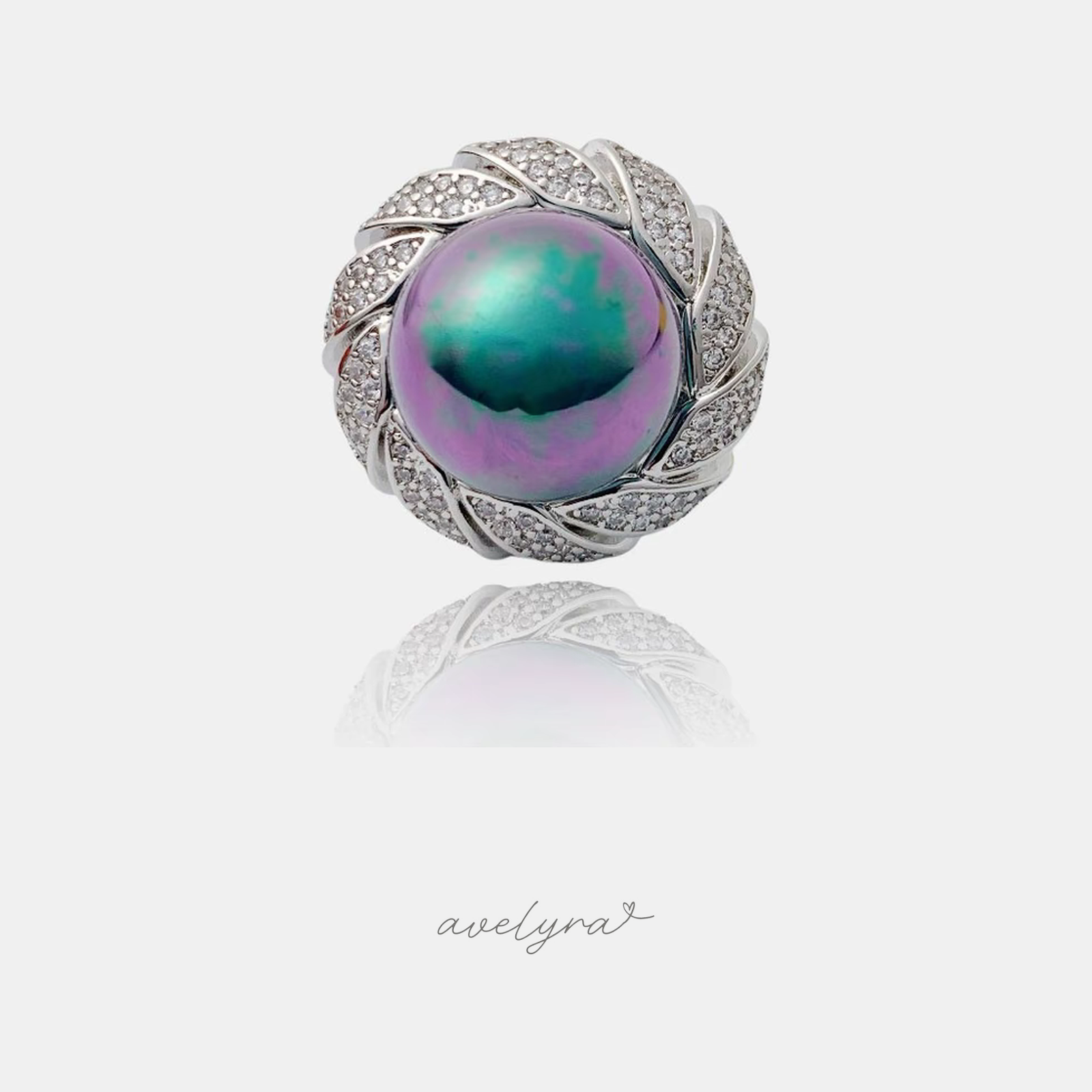 Silver-tone cocktail ring with a large iridescent green-and-purple pearl wrapped in swirled pave