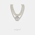 Multi-strand ivory pearl necklace with a large silver-tone crystal-paved rose flower centrepiece.