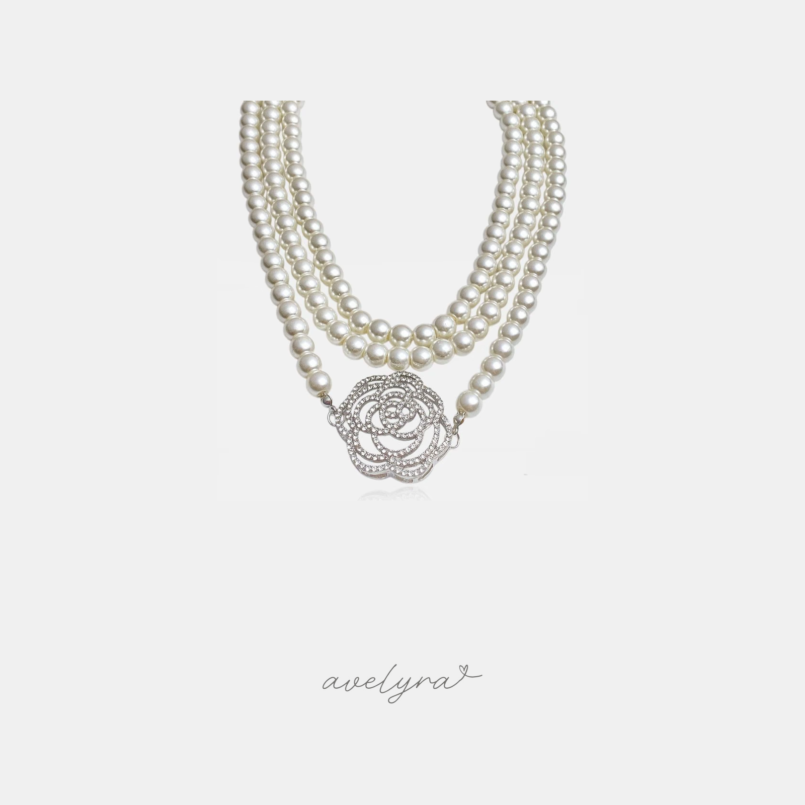 Multi-strand ivory pearl necklace with a large silver-tone crystal-paved rose flower centrepiece.