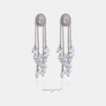 Silver-tone earrings with an oval crystal halo top and dangling clusters of frosted white round beads.