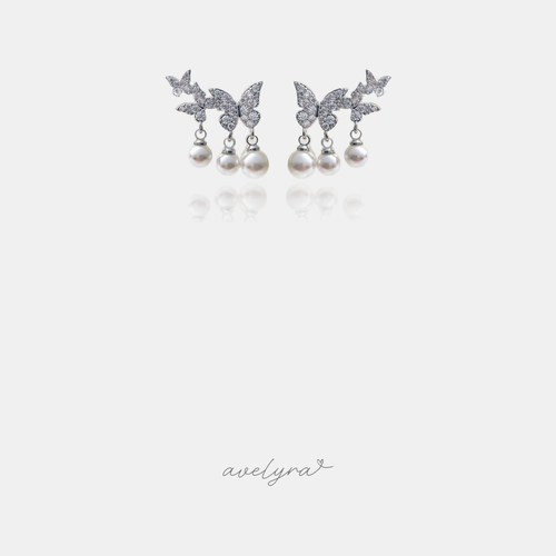 Silver-tone earrings with pave butterflies and three small white pearl drops each.