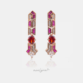 Rose gold-tone geometric drop earrings with magenta and crimson stones and a central red stone.