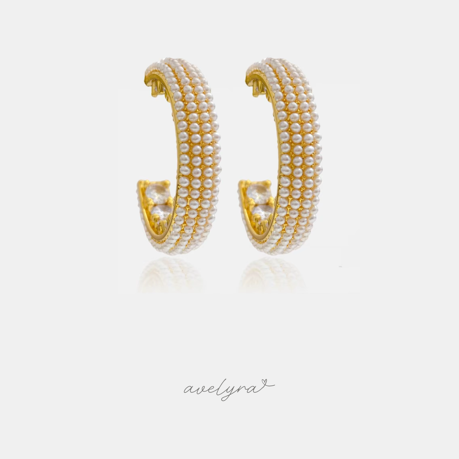 Gold-tone open hoop earrings densely covered with small ivory pearls.
