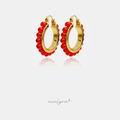 Gold-tone hoop earrings edged with a row of glossy red round beads.