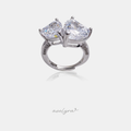 Silver-tone ring with two clear heart-cut crystals side by side on a pave band
