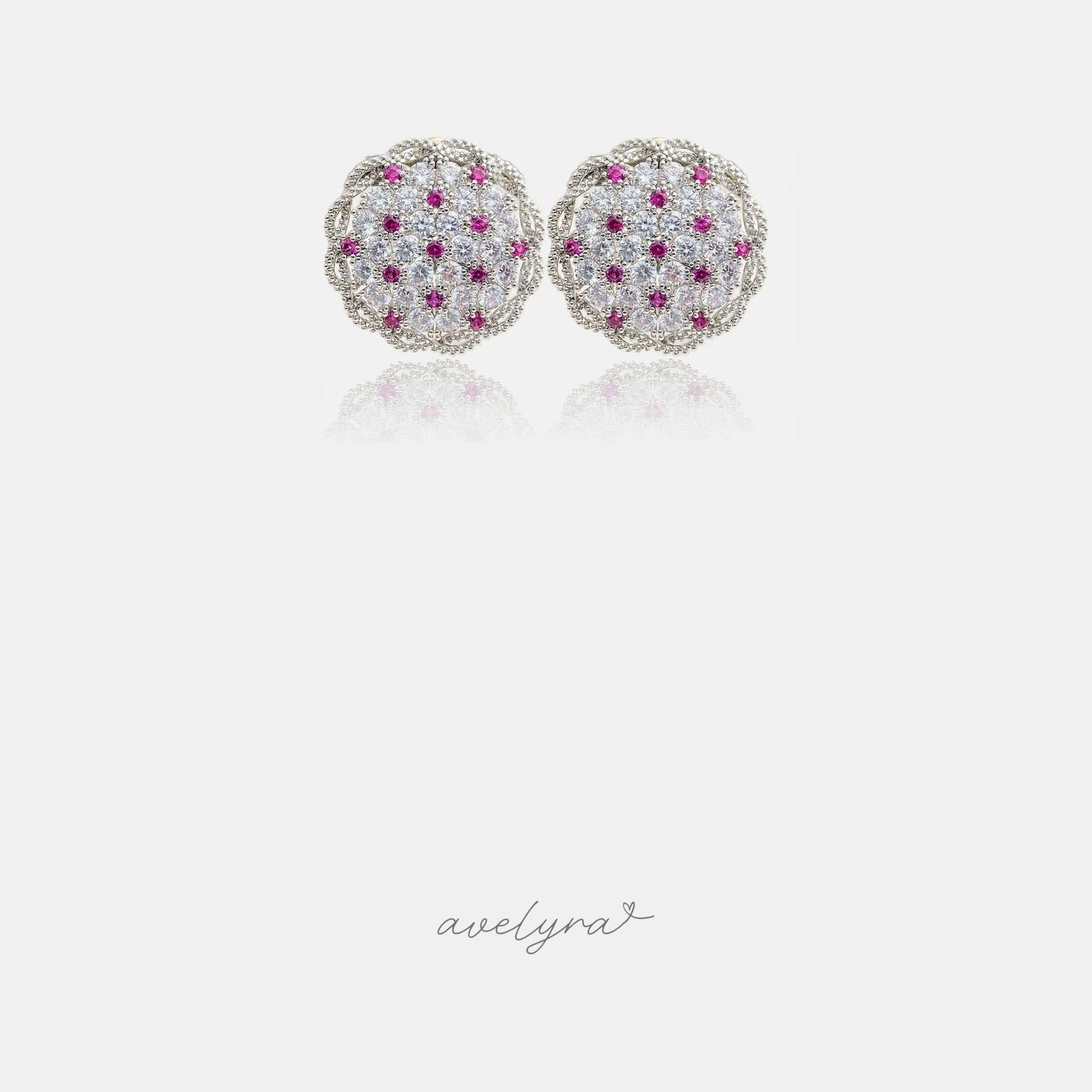 Silver-tone round dome stud earrings with clear pave crystals and scattered magenta-pink stones.
