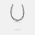 Multi-strand black beaded necklace with scattered pearls in grey, gold, cream, peach and lavender.