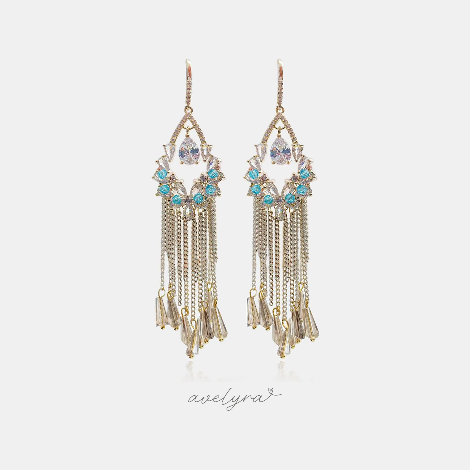 Gold-tone chandelier earrings with a pear-shaped clear crystal, small aqua-blue beads and chain fringe ending in champagne baguette drops.