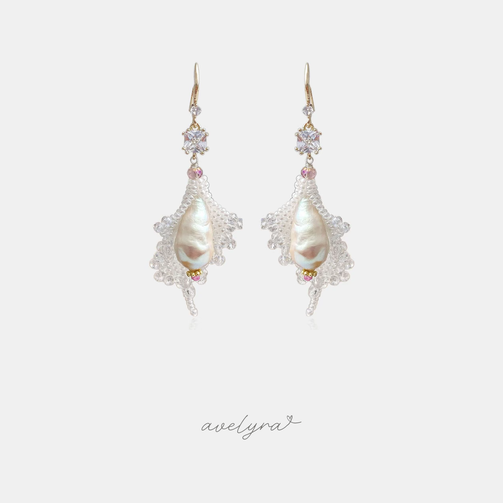 Gold-hook drop earrings with a large ivory baroque pearl surrounded by a fan of clear beaded crystals and pink accents.