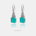 Silver-tone hook earrings with a large square sea-green stone below a tapering column of clear baguette crystals.