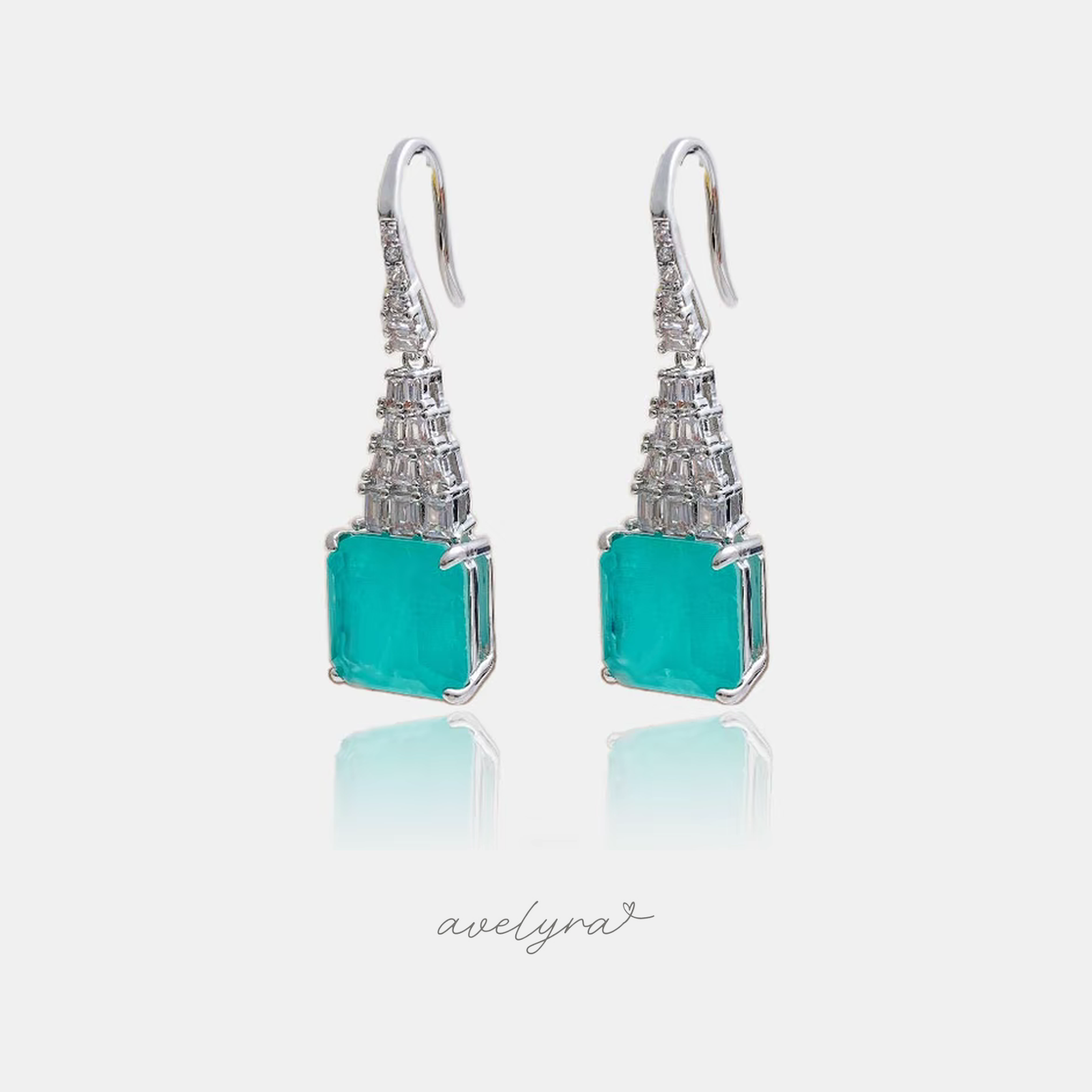 Silver-tone hook earrings with a large square sea-green stone below a tapering column of clear baguette crystals.