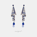 Silver-tone drop earrings with a geometric art-deco design of blue baguette stones and clear crystals ending in a blue pear-shaped stone.