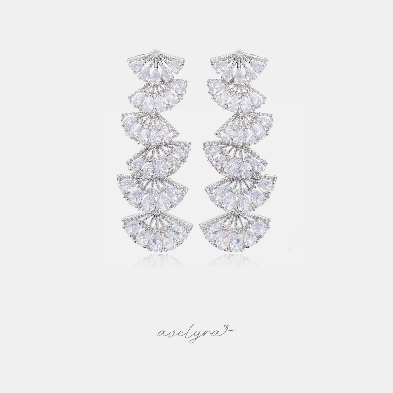 Long silver-tone earrings made of stacked fan-shaped clusters of clear marquise and pear-cut crystals.