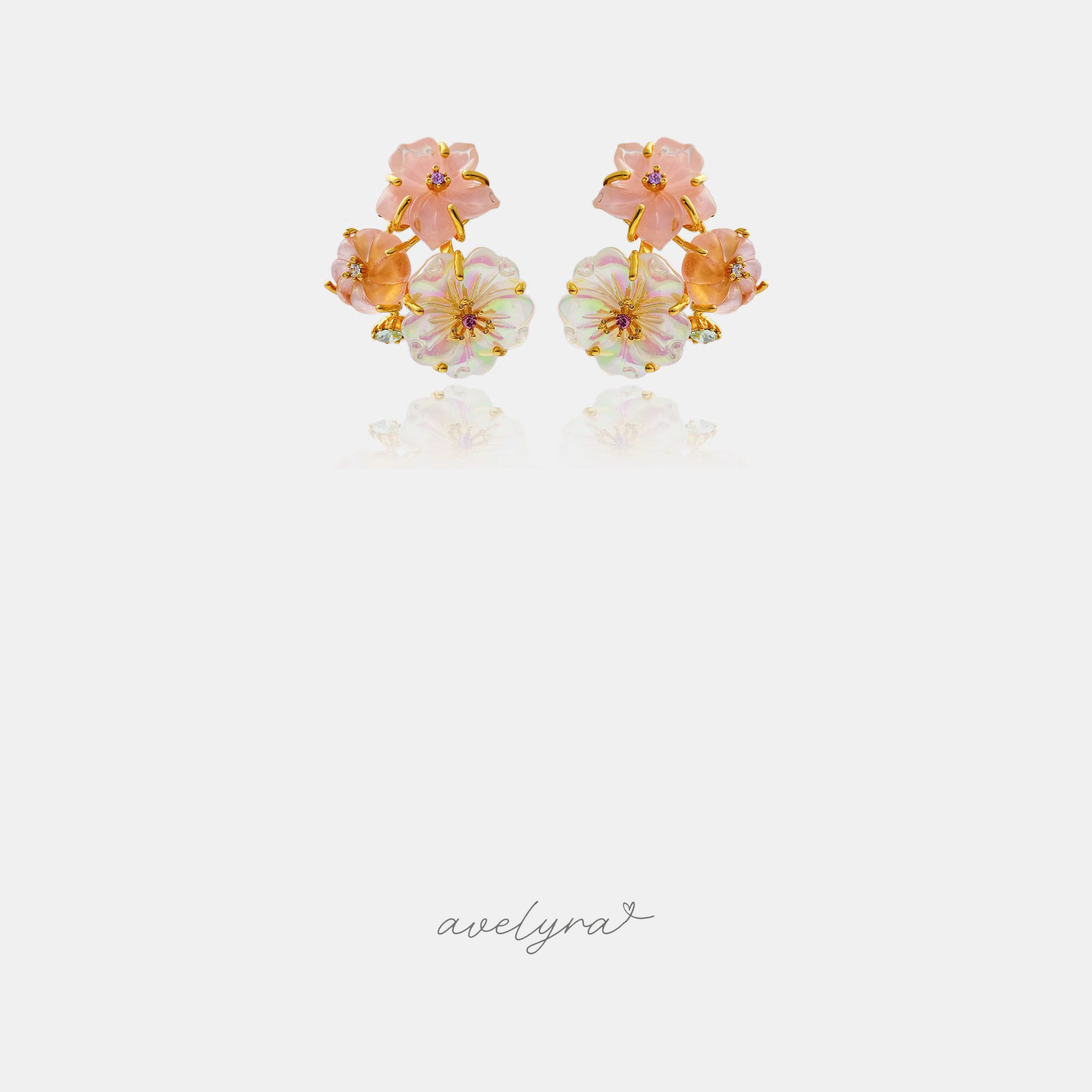 Gold-tone cluster stud earrings of carved pink and iridescent white flowers with small crystal accents.