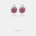 Silver-tone stud earrings with a large pink rose-cut stone below a small clear round crystal.