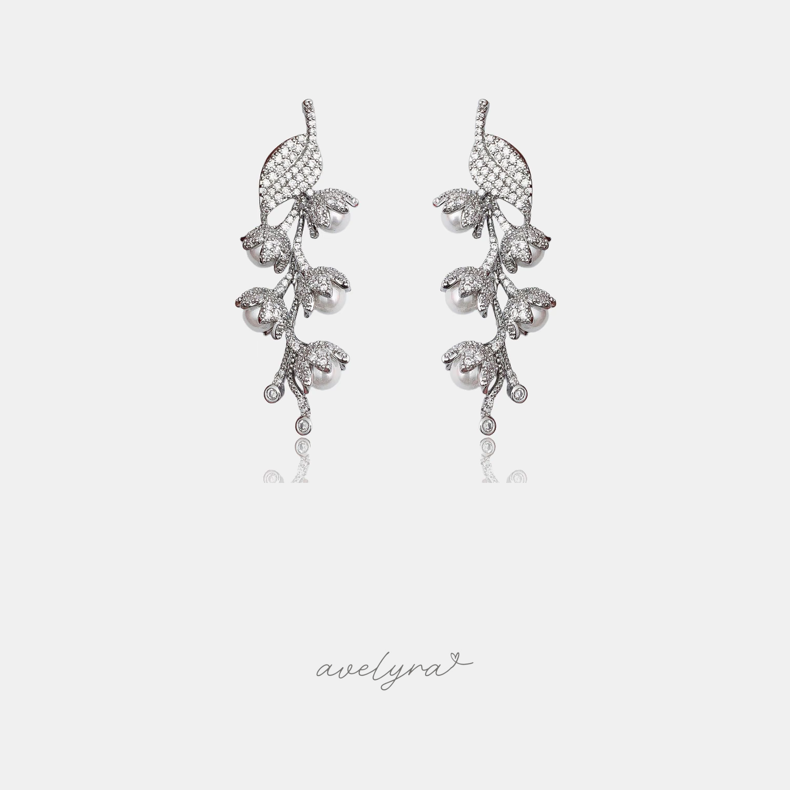 Pair of silver leaf-vine climber earrings set with crystals and small pearls.