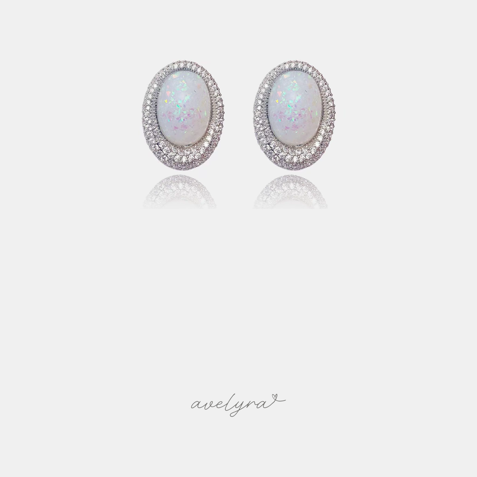Oval stud earrings with iridescent white opaline centre stones surrounded by a double halo of clear crystals.