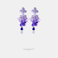 Dangle earrings made of layered lilac and violet flower petals ending in a deep blue-purple teardrop bead.