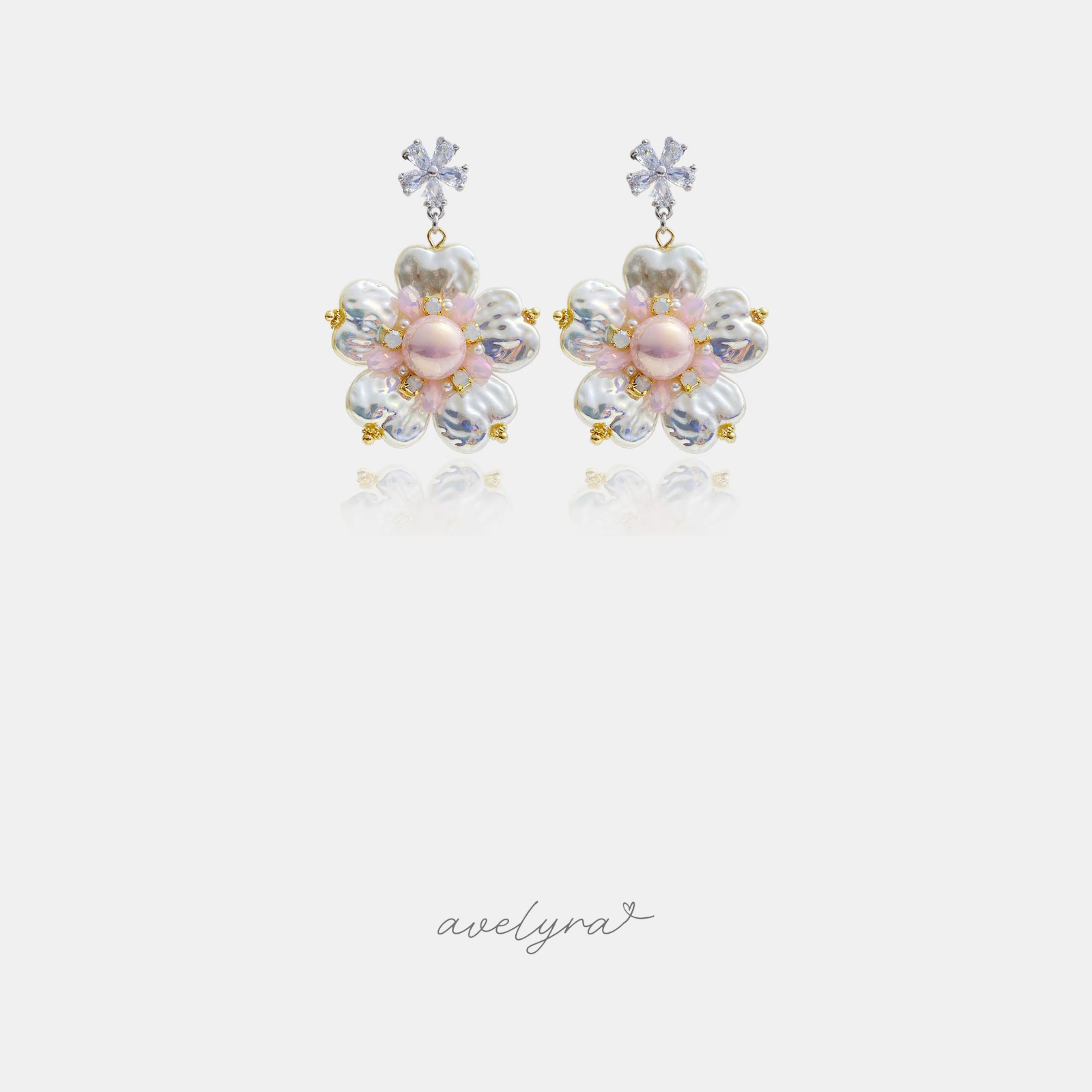 Flower drop earrings with pearl petals, a pink centre bead and a clear crystal flower above.