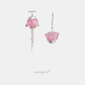 Asymmetric pink flower-shaped drop earrings with pearl accents and a hanging pearl chain.