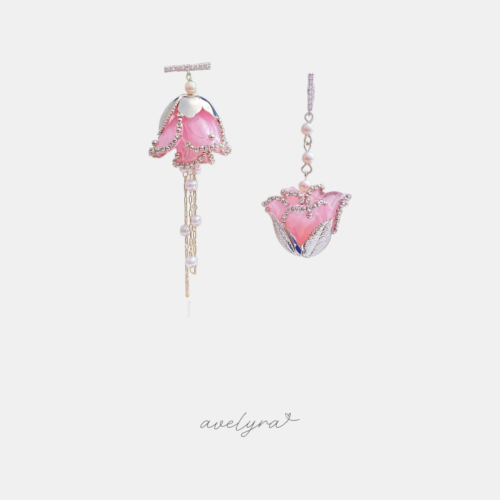 Asymmetric pink flower-shaped drop earrings with pearl accents and a hanging pearl chain.