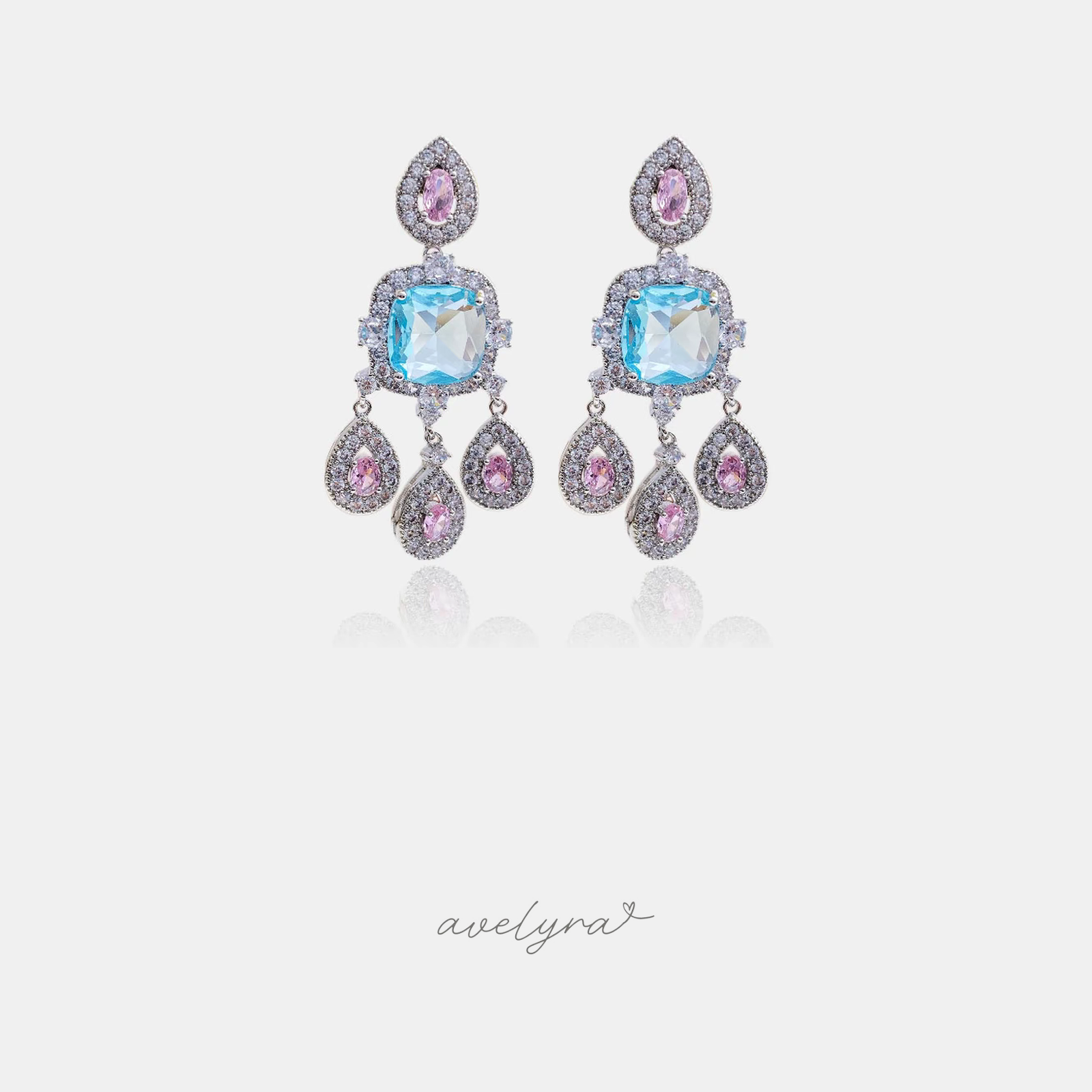 Silver-tone chandelier earrings with an aqua-blue cushion stone, pink accents, and three teardrop drops.