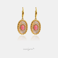 Gold-tone drop earrings with a scalloped oval mother-of-pearl medallion and a coral-pink centre stone ringed with small clear stones.