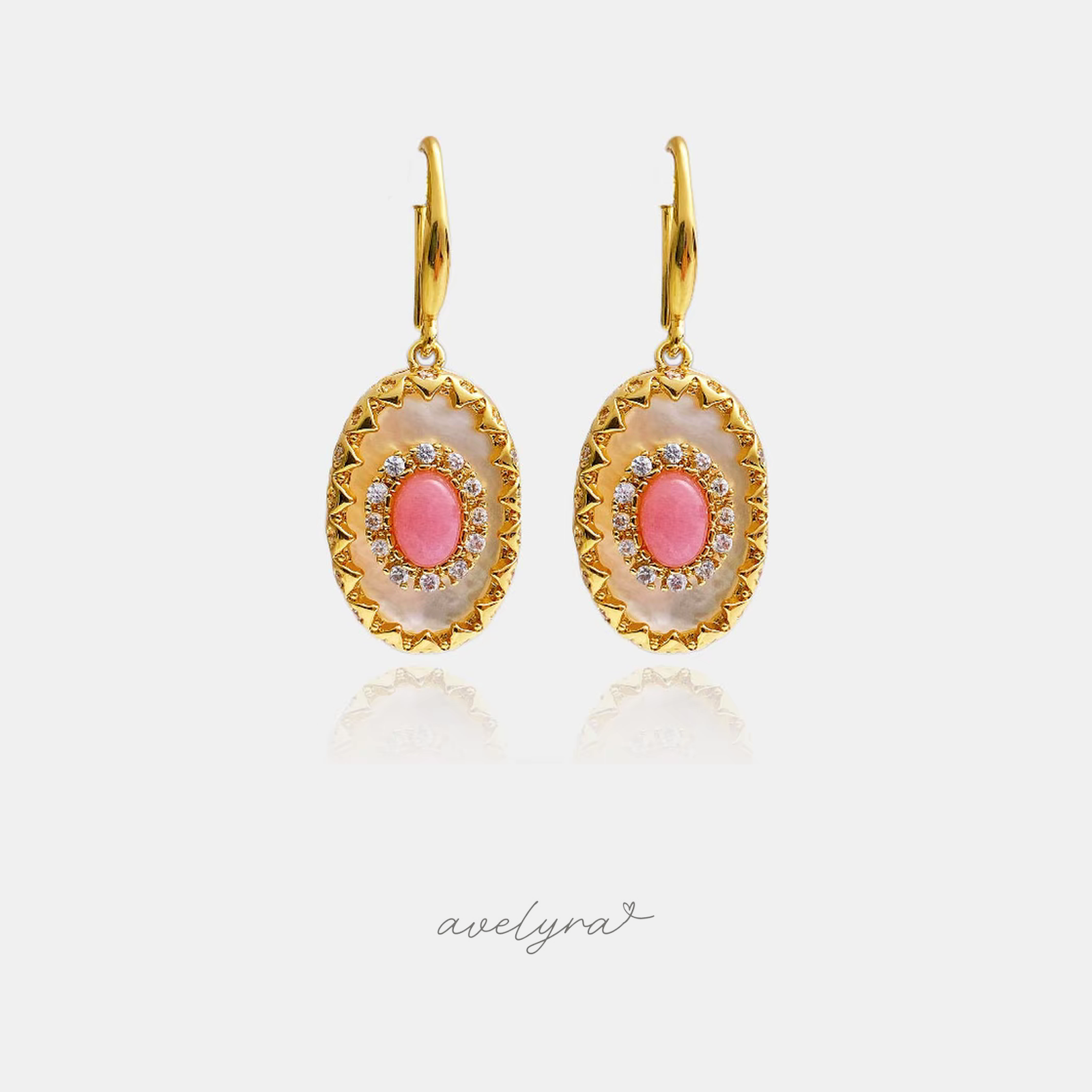 Gold-tone drop earrings with a scalloped oval mother-of-pearl medallion and a coral-pink centre stone ringed with small clear stones.