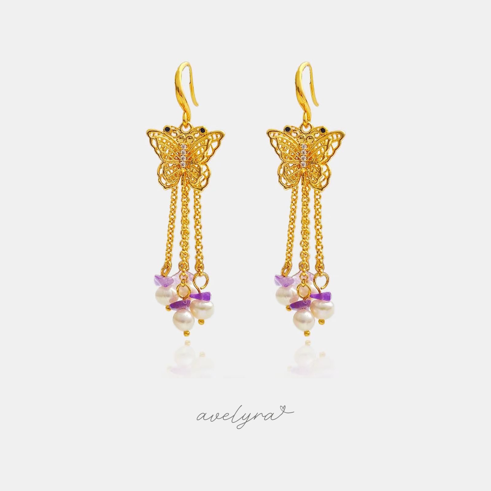 Gold-tone butterfly hook earrings with cascading chains of pearls and violet stone chips.