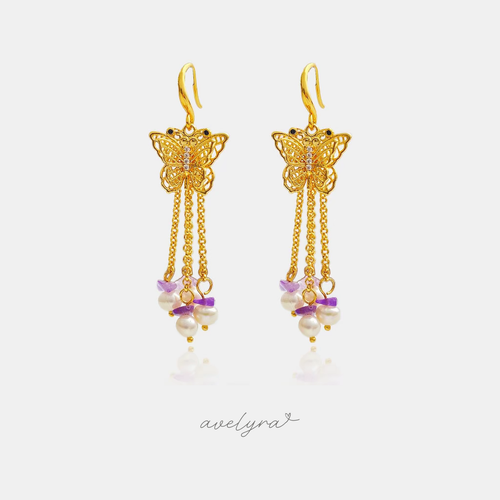 Gold-tone butterfly hook earrings with cascading chains of pearls and violet stone chips.