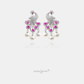Silver-tone peacock chandelier earrings with clear crystal plumage, magenta stones and three pearl drops.