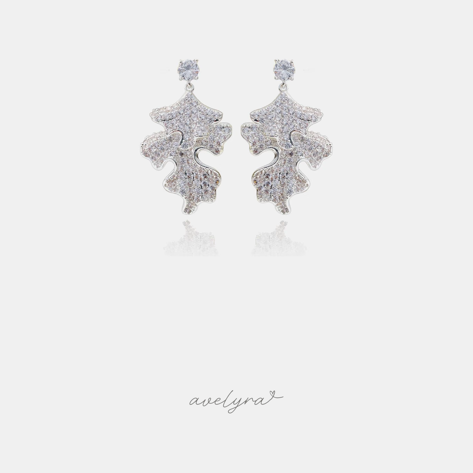 Silver-tone drop earrings with a crystal stud and fully crystal-paved wavy leaf shapes.