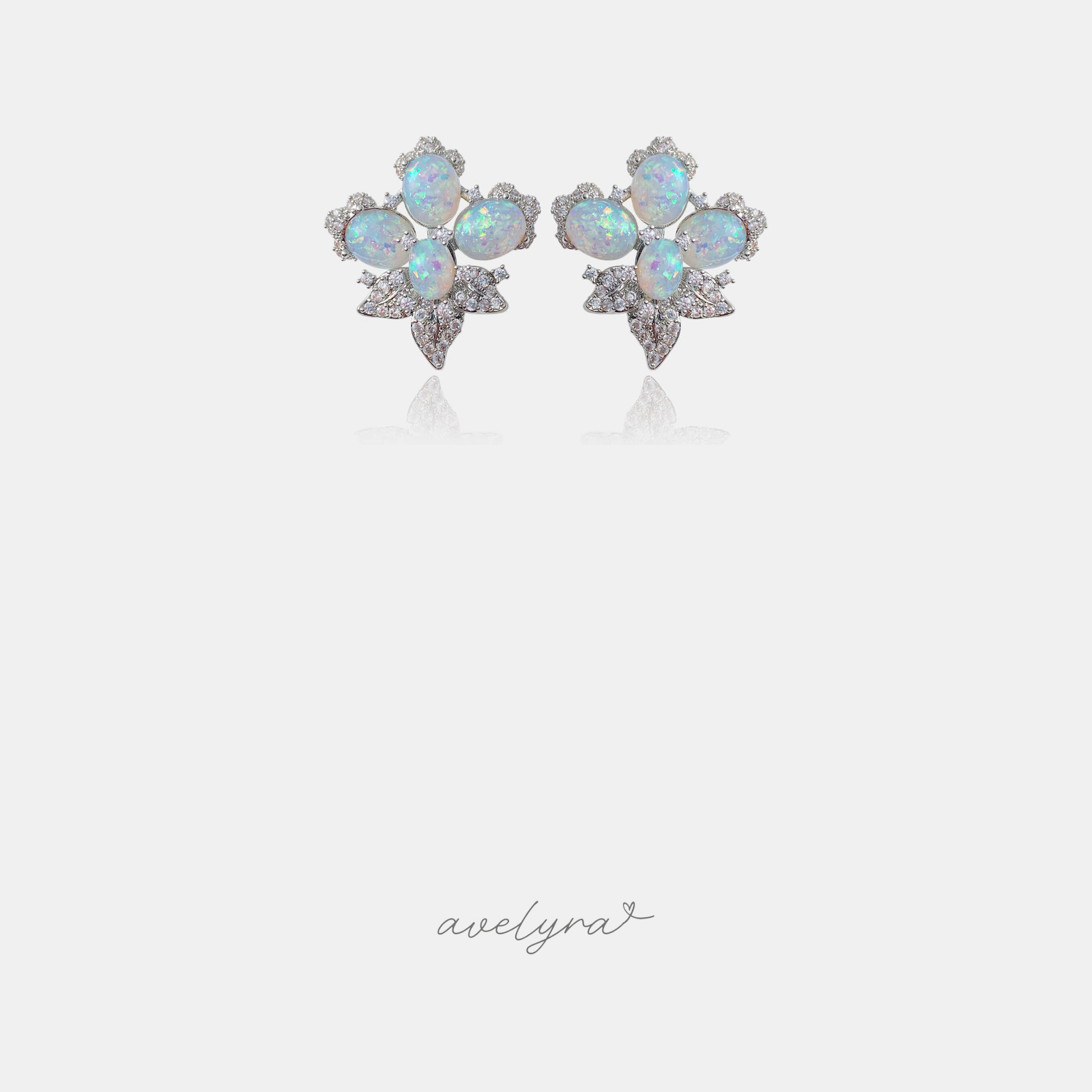 Silver-tone cluster stud earrings with iridescent white oval stones and clear crystal accents.