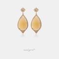 Gold-tone drop earrings with crystal star stud and large honey-yellow teardrop stone in a pave halo.