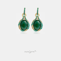 Gold-tone drop earrings with green oval cabochon framed by teal crystals and a pave bar top.