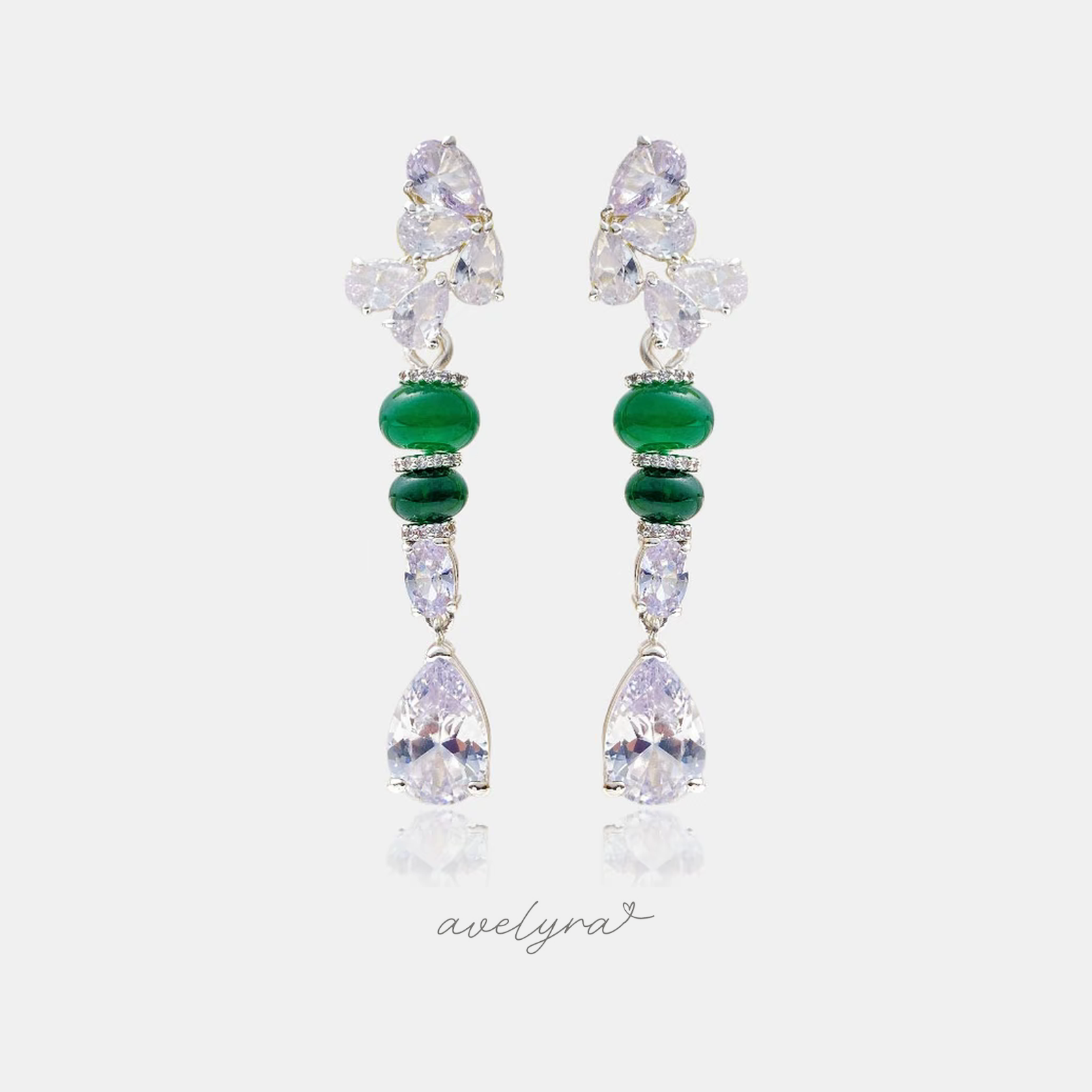 Silver-tone drop earrings with clear pear crystals, green cabochon beads and a clear teardrop crystal.