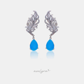 Silver-tone feather-shaped drop earrings with a blue teardrop stone.
