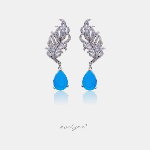 Silver-tone feather-shaped drop earrings with a blue teardrop stone.