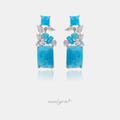 Silver-tone dangle earrings with clustered blue and clear stones and a large aqua drop.