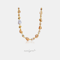 Beaded necklace with caramel stone beads, shell discs, grey baroque pearl and gold accents.