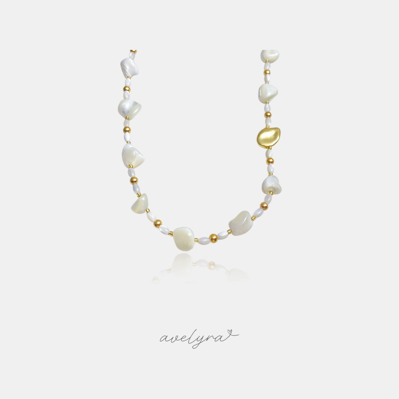 Beaded necklace with white shell nuggets, small pearls and gold beads including a smooth gold pebble.