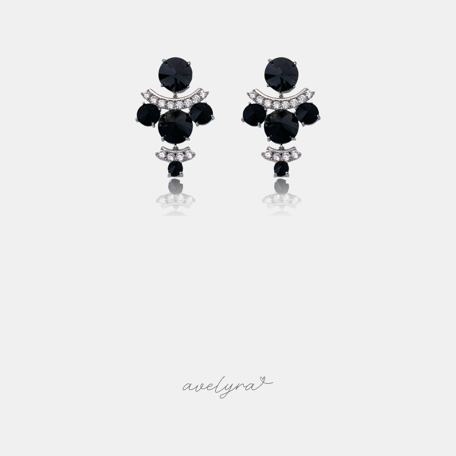 Pair of drop earrings clustering round black stones with arcs of clear crystals.