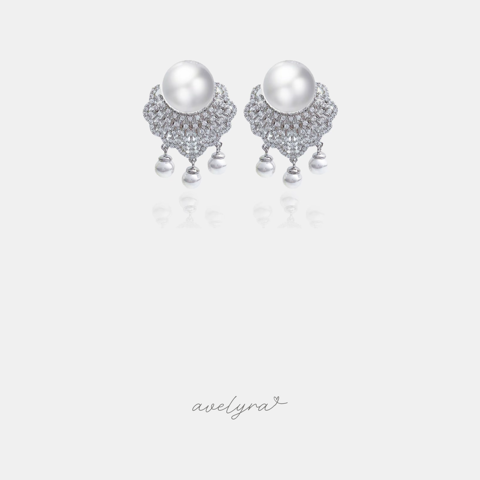 Drop earrings with a large white pearl above a crystal-set fan and three small dangling pearls.