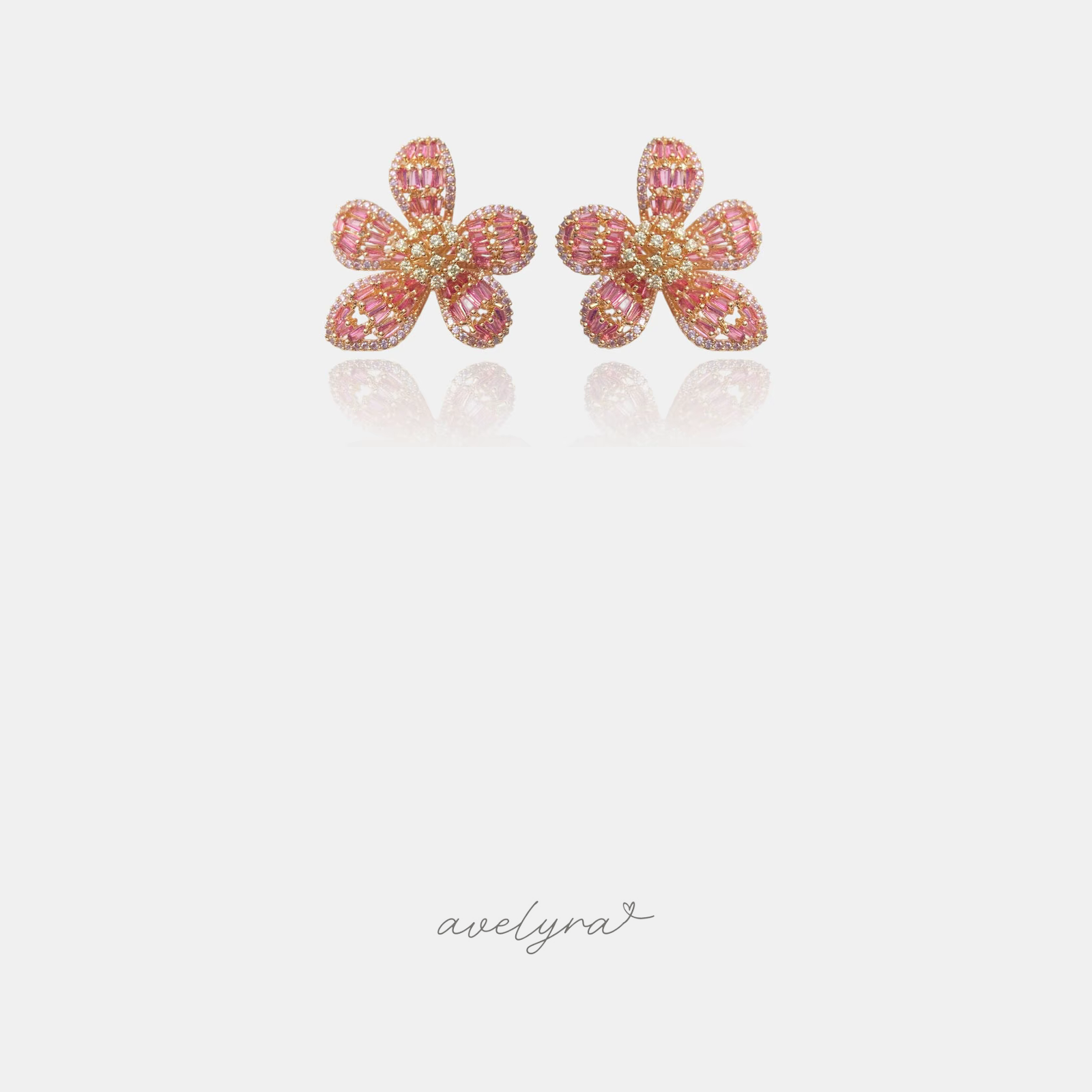Gold-tone flower stud earrings with pink baguette stone petals and a crystal centre.