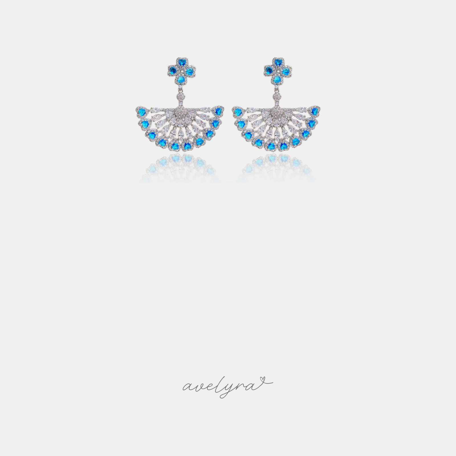 Silver-tone fan-shaped chandelier earrings with blue and clear stones.