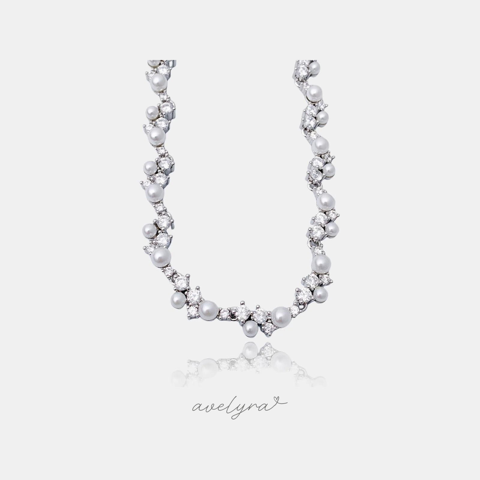 Silver-toned collar necklace with clusters of round pearls and sparkling clear stones.