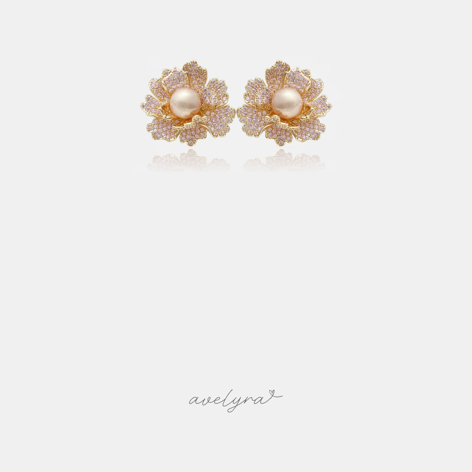 Gold-tone flower stud earrings with pink pave petals surrounding a single cream pearl centre.